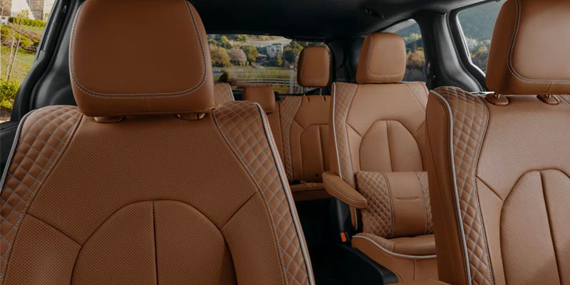 Premium Chrysler Pacifica cabin featuring quilted tan leather seats across multiple rows with a spacious interior layout.