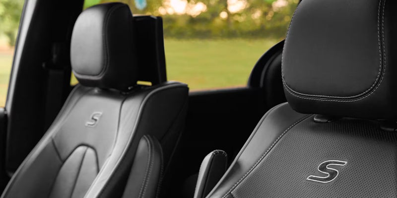 Close-up of black leather Chrysler Pacifica seats featuring embroidered “S” logos and premium interior upholstery