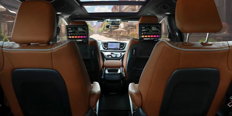 Chrysler Pacifica interior featuring rear-seat entertainment screens, premium seating, and a panoramic sunroof extending across the cabin