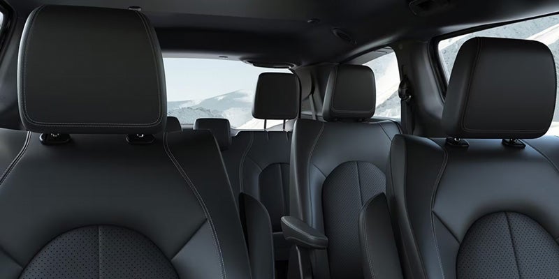 Interior cabin view of a Chrysler minivan featuring multiple rows of seating with headrests and ample passenger space.