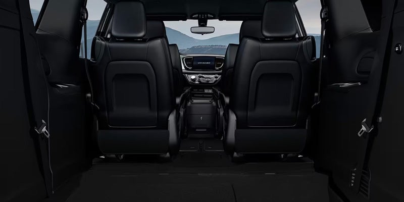 Rear cargo area of a Chrysler minivan with seats folded down, providing a large flat storage space extending toward the front seats
