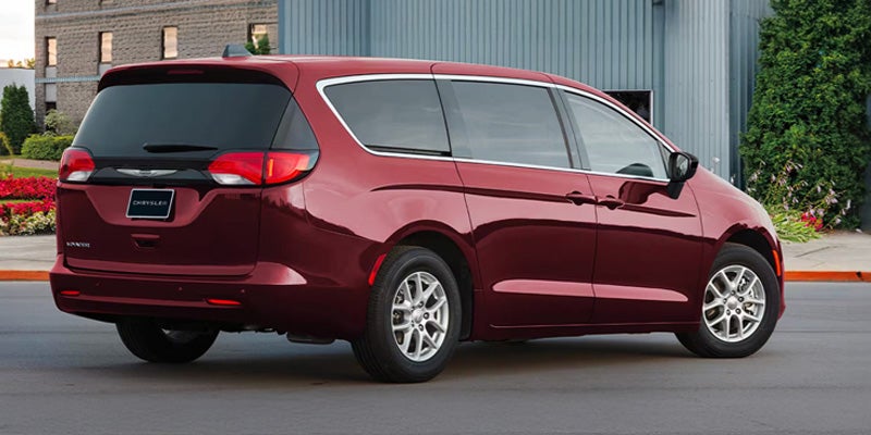 Red Chrysler minivan shown from a rear-side angle, highlighting the vehicle's exterior design, taillights