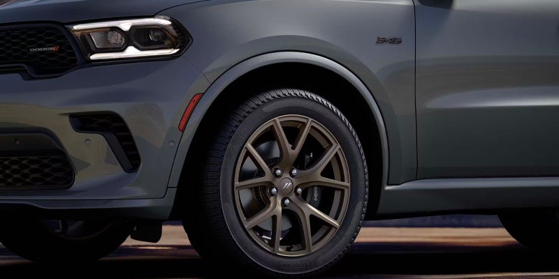 Close-up of a Dodge Durango front wheel, tire, and fender, highlighting the alloy wheel design
