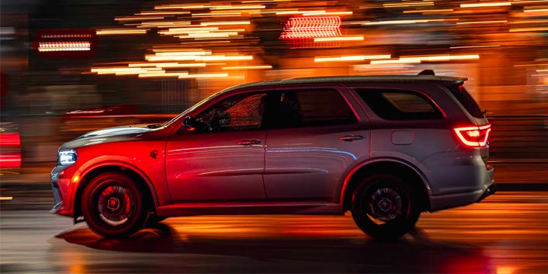 Silver Dodge Durango SRT Hellcat driving through a city at night, with motion blur
