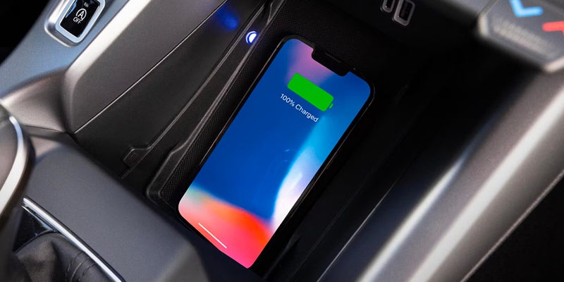 Smartphone charging on the wireless charging pad in the center console of a Dodge Hornet.