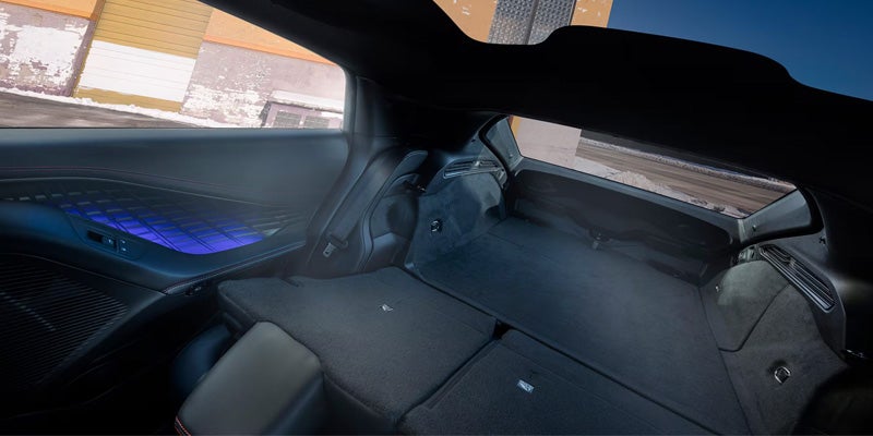 Spacious rear cargo area of a Dodge Charger Daytona with folding rear seats and illuminated interior accents.