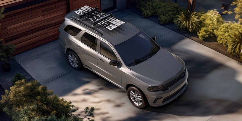 Overhead view of a Dodge Durango parked in a driveway with roof-mounted cargo accessories and a panoramic roof.