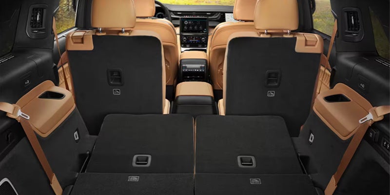 View of a spacious car interior looking forward from the trunk, with the third row seats folded flat for cargo.