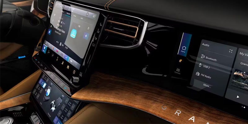 High-tech car interior showing multiple digital screens displaying navigation, audio, and vehicle controls.