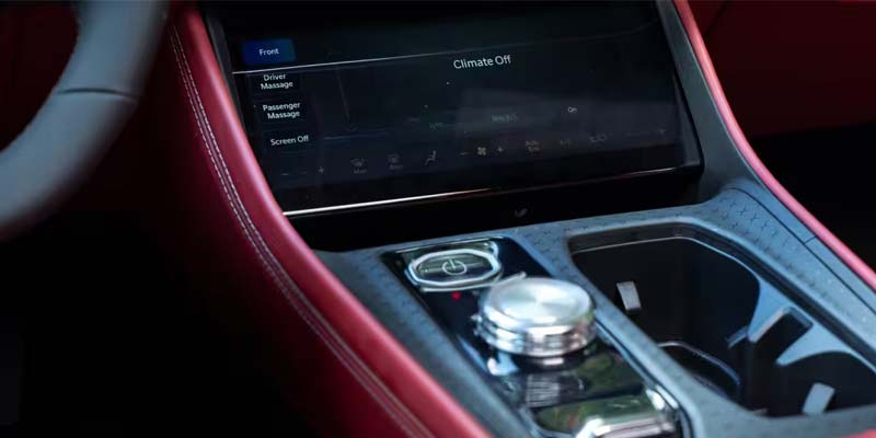 A car's interior with a large touchscreen displaying "Climate Off," "Driver Massage," and "Passenger Massage" options.