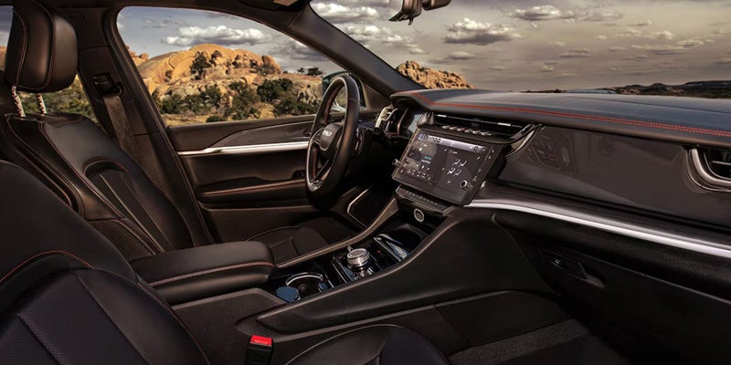 Luxurious Jeep Grand Wagoneer interior featuring leather seating, a large touchscreen display