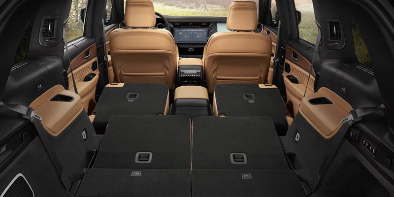 Jeep Grand Wagoneer cargo area with rear seats folded flat, creating an expansive storage space behind the front seats.