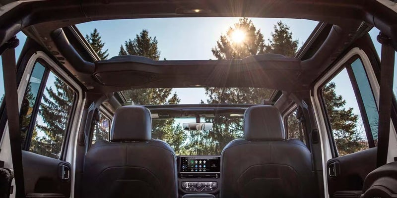 Interior view of an SUV featuring a panoramic roof, front seats, and dashboard
