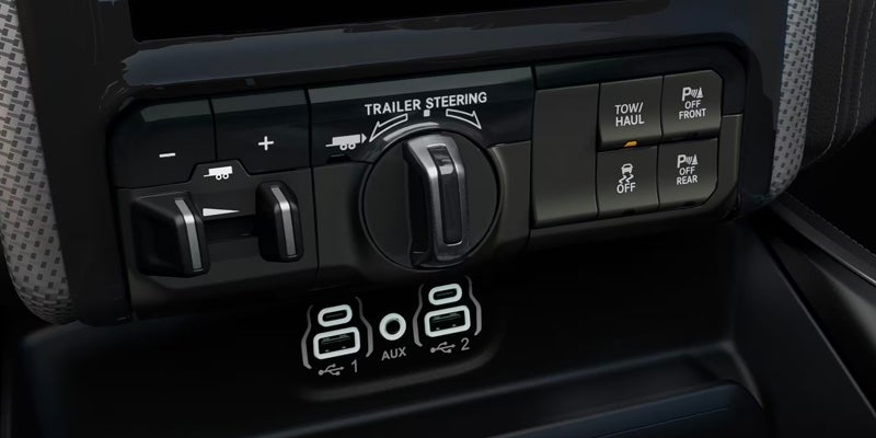 Vehicle controls for trailer steering, tow/haul, parking assist, and traction control, with USB and auxiliary ports.
