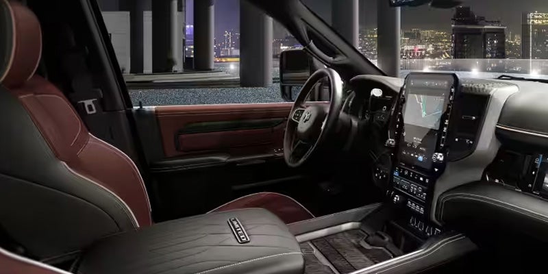 View from the passenger seat of a car interior at night with city lights in the background.