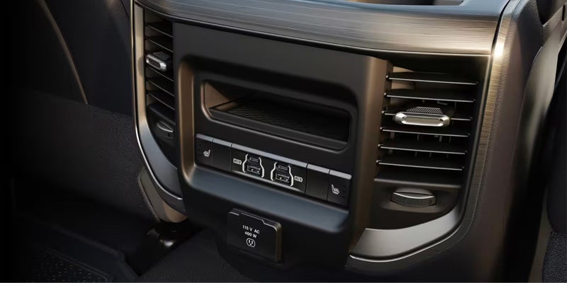 Rear console with two air vents, dual USB charging ports, two heated seat buttons, and a 115V AC outlet.